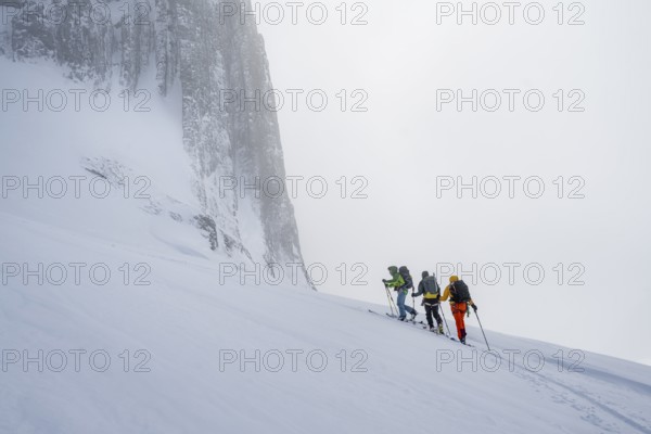 Dramatic atmosphere, Ski tourers, Snowy mountain landscape, Bernese Alps, Bernese Oberland, Switzerland, Europe