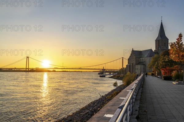 The Emmerich Rhine Bridge, federal road B220, evening light, at 803 m the longest suspension bridge in Germany just in front of the Dutch border, Rhine kilometre 853, 2 it is the northernmost German Rhine bridge, Rhine promenade, St. Martini Church, North Rhine-Westphalia, Germany, Europe