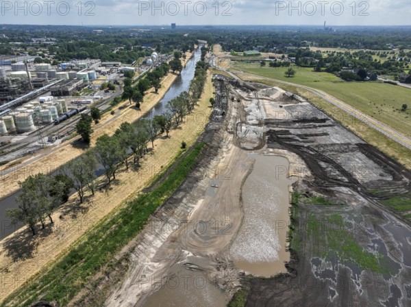 Oberhausen, North Rhine-Westphalia, Germany, renaturalisation of the Emscher in the Holtener Bruch. On the right, a newly designed floodplain stillwater. Left OQ Chemicals plant Ruhrchemie. The currently straightened Emscher, shown here at flood level, has been given curves again and can meander through its new floodplain. The ecological conversion of the Emscher system consists of the construction of a centralised wastewater treatment system in the Ruhr region, the construction of sewers and the renaturation of the Emscher and its tributaries. Following the construction of a parallel sewer, the Emscher has been completely free of sewage since January 2022. The river was previously an open, above-ground combined sewer with rainwater and wastewater, Europe