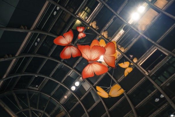 Artistic representation of large red and orange butterflies under an illuminated railing, Calwer Tor, Stuttgart, Germany, Europe
