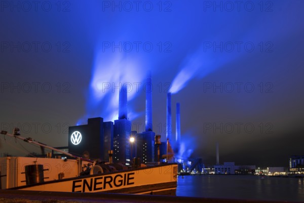 Illuminated cogeneration plant of Volkswagen, Volkswagen logo, the sky above the Mittelland Canal is bathed in blue, Wolfsburg, Lower Saxony, Germany, Europe