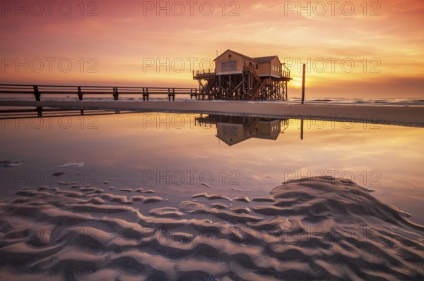 Stilt house on the beach at sunset, reflection in tidal pool, St. Peter-Ording Schleswig-Holstein Wadden Sea National Park, Schleswig-Holstein, Germany, Europe