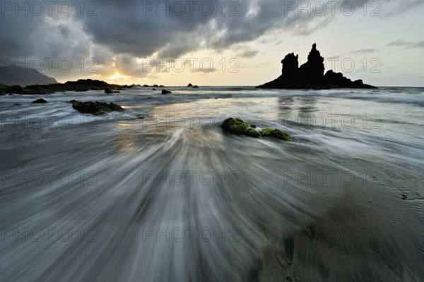 Dramatic cloudy atmosphere with rock formation at rising tide at sunset on the beach of Playa de Benijo, Tenerife, Canary Island, Spain, Europe