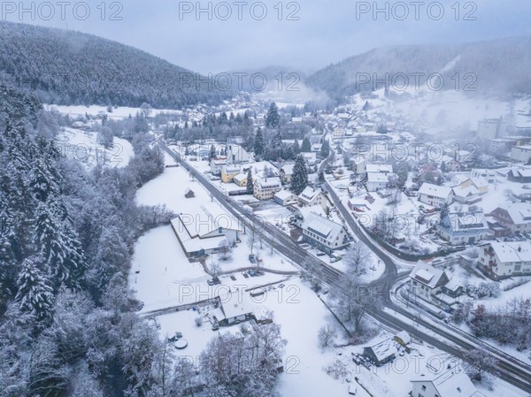 Snow-covered village surrounded by forests and hills. A wintry and foggy atmosphere, Enzklösterle, district of Calw, Black Forest, Germany, Europe