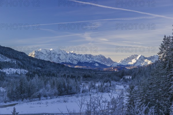 Isar valley in winter at temperatures of minus 18 degrees Celsius. Snow covered landscape with the Isar river flowing through. Some hoar frosted trees. Early morning