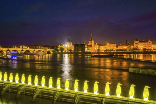 Yellow penguins, installation by the Italian artist group 'Cracking Art Group' on the Vltava River, with the old town behind it, Muzeum Kampa, Prague, Czech Republic, Europe