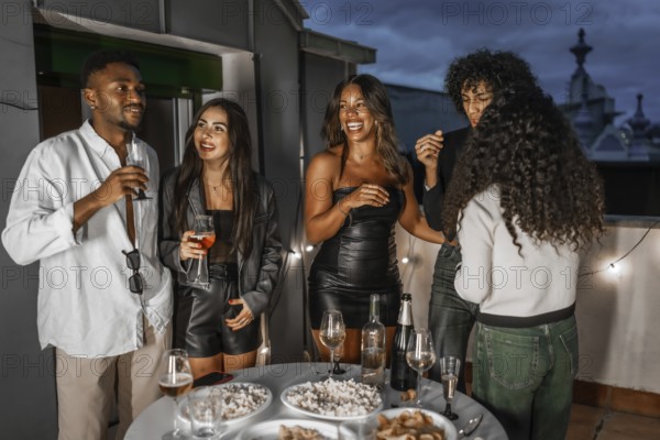 Multi-ethnic elegant friends enjoying night in a roof drinking champagne and talking