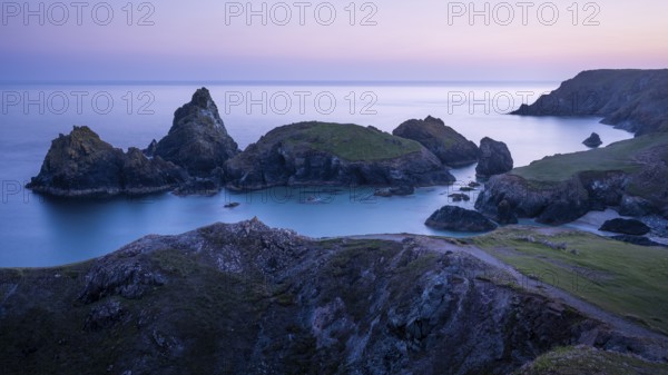 Kynance Cove with Asparagus Island, with sea, sandy beach and rocks in the evening. Coastal landscape. Blue hour. Long exposure. Good weather, blue sky. Kynance Cove, Lizard Peninsula, Cornwall, England, Great Britain