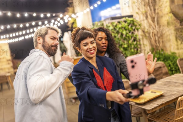Female caucasian vlogger streaming online using the smartphone in a night party with friends