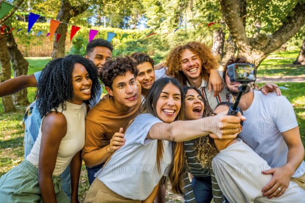 Multi-ethnic happy young friends taking selfie after celebrate birthday in a park