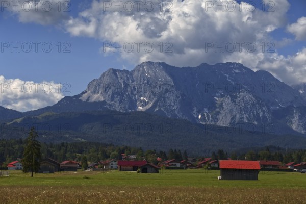 A mountain landscape with a village in the foreground, surrounded by meadows and mountains under a blue sky, Wallgau, Bavaria, Germany, Europe