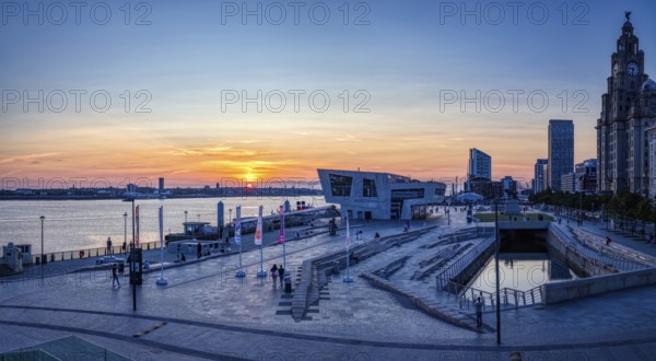 Modern harbour view at sunset with river and city in the background, Liverpool