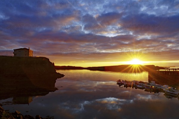 Sunset over the sea with reflecting clouds and a calm coast, Stykkisholmur, Snaefelsnes, Iceland, Europe