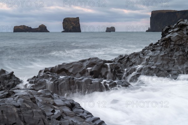 Waves, surf, washed over columnar basalt, rock needles, long exposure, Dyrhólafjara, rock gate Dyrhólaey or Dyrholaey, south coast, Iceland, Europe