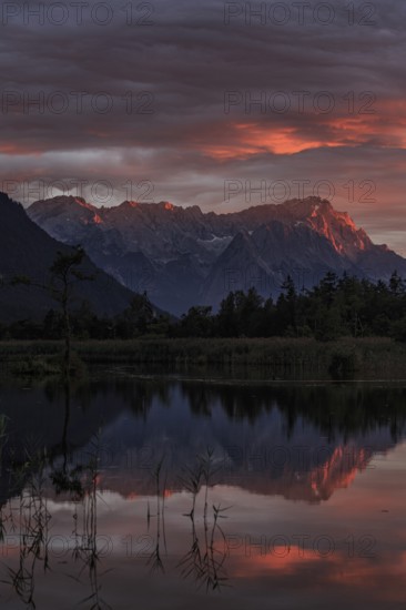 Mountains reflected in lake, sunset, cloudy mood, alpenglow, summer, seven springs, behind Zugspitze, Wetterstein mountains, Bavaria, Germany, Europe