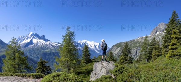 Mountaineer standing on rocks, mountain panorama with glaciated mountain peaks, Aiguille Verte with Aiguille du Midi and Mont Blanc, hike to Aiguillette des Posettes, Chamonix, Haute-Savoie, France, Europe