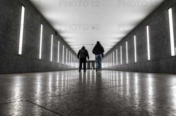 Two men walking through the tunnel subway illuminated with LED light to the underground station Museum Island, Berlin, 07/02/2025, Berlin, Berlin, Germany, Europe