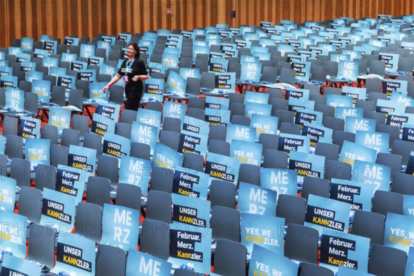 Assembly hall, deserted with many empty chairs and posters with the inscription UNSER KANNZLER. Bundestag election campaign of the CDU party for the party's candidate for chancellor Friedrich Merz, symbolic photo. Election rally in Künzelsau, Baden-Württemberg, Germany, Europe