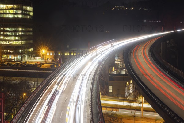 Federal road B14 at night, road bridge with traffic and light lanes. On the left the building of the Social Insurance for Agriculture, Forestry and Horticulture (SVLFG) . Stuttgart, Baden-Württemberg, Germany, Europe