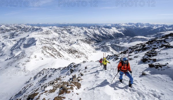 Ski tourer on foot, carrying skis on backpack, mountain panorama, snow-covered mountain landscape in winter, high tour, ascent to Monte Cevedale, Ortler Alps, Vinschgau Valley, Italy, Europe