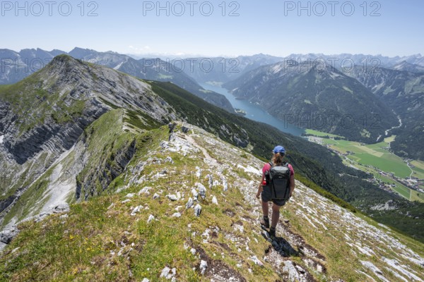Mountaineer on the summit ridge of the Unnütz, behind Achensee and summit of the Seekarspitze Unnütz crossing, Brandenberg Alps, Tyrol, Austria, Europe