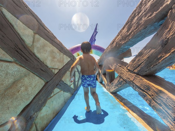 Child walking on water park attraction during summer vacation in alicante, mediterranean sea