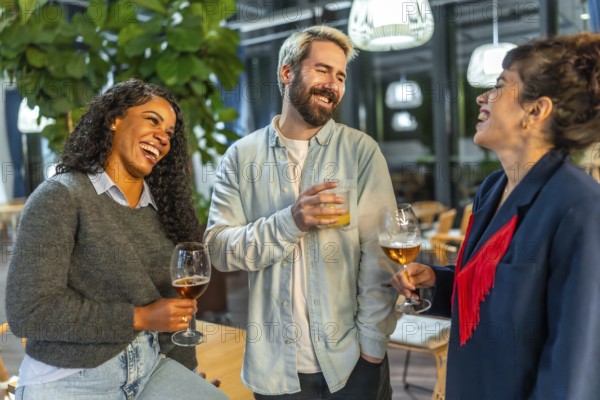 Modern people drinking beer and chatting happily in the terrace of a bar at night