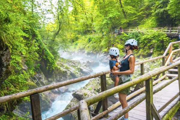 Mother carrying her child while admiring the breathtaking vintgar gorge near bled, slovenia, during summer