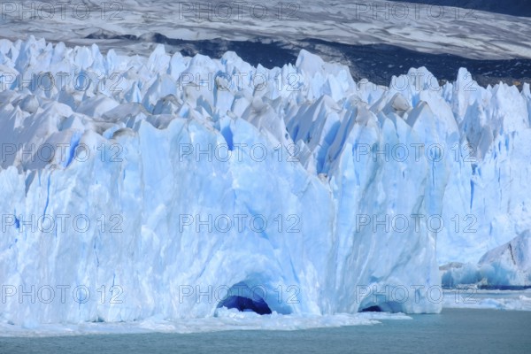 El Calafate, Patagonia, Argentina, Perito Moreno Glacier in Los Glaciares National Park. The Perito Moreno Glacier is part of the Patagonian ice field, the Campo Hielo Sur, the third largest freshwater reserve in the world. It is located in the province of Santa Cruz on Lago Argentino, the country's largest lake. The Perito Moreno Glacier is up to 30 kilometres long and 5 kilometres wide. Its edge is 70 metres high at its highest point. Small icebergs that have broken off from the glacier float in Lago Argentino. The glacier is one of the most beautiful sights in South America and is one of the most visited attractions in Argentina, South America