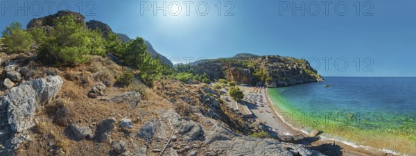 Expansive Ahata Beach panorama with beach, mountain backdrop and bright sunlight over the sea, Ahata Beach, Aperi, Karpathos, Greece, Europe