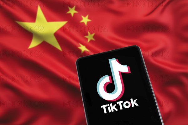 TikTok logo from China with Chinese flag social media on a mobile phone in Stuttgart, Germany, Europe