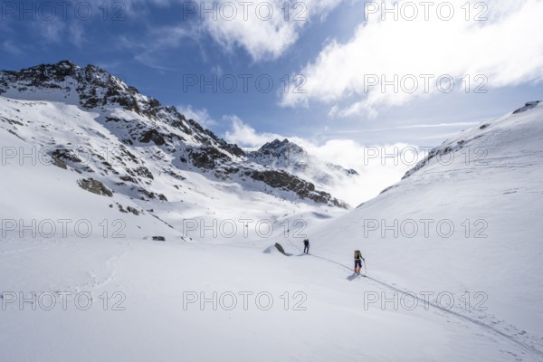 Atmospheric clouds in a wintry mountain landscape, ski tourers on the ascent to Porta d'Es-cha, Grisons Haute Route ski tour, Albula Alps, Rhaetian Alps, Grisons, Eastern Switzerland, Switzerland, Europe