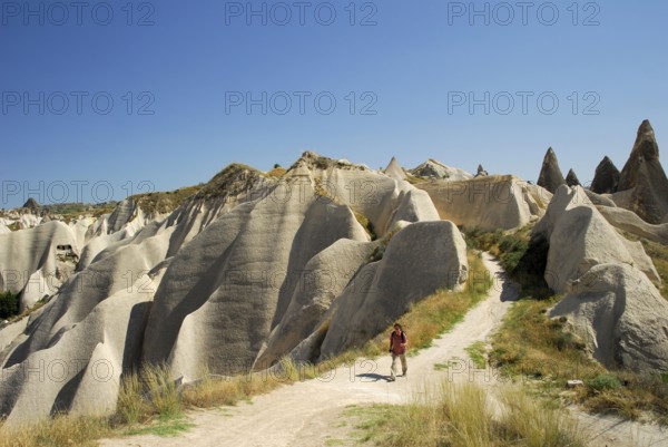 Hiker between tuff rocks, Rose Valley, Rose Valley, Cappadocia, Turkey, Asia
