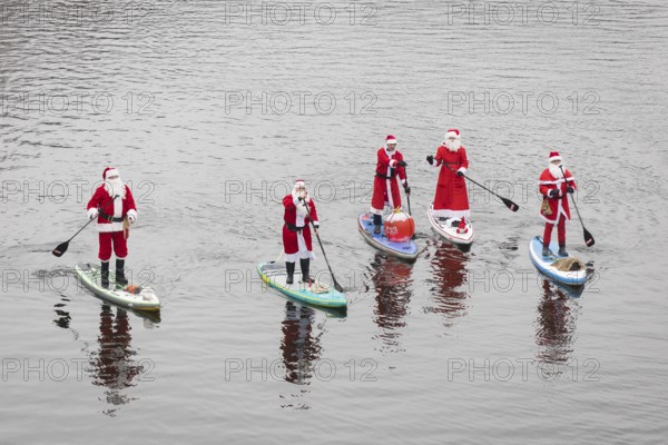 Water sports enthusiasts dressed as Santas ride SUPs on the Spree in Berlin on 14 December 2024