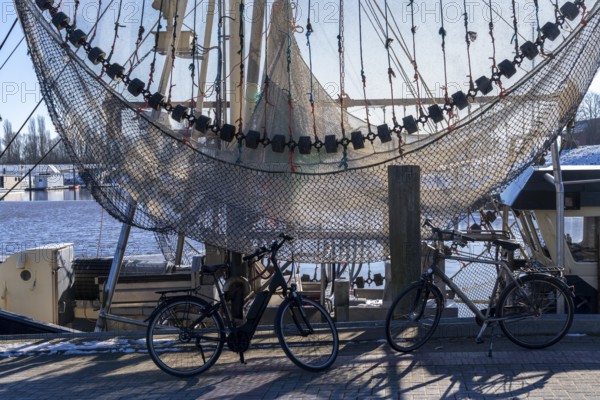 The fishing village of Greetsiel, historic fishing harbour, with the largest shrimp cutter fleet in East Frisia, fishing nets, fishing nets, winter, Lower Saxony, Germany, Europe