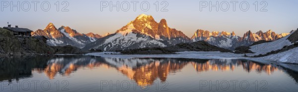 Evening mood, mountain landscape at sunset, alpenglow, water reflection in Lac Blanc with mountain hut Refuge du Lac Blanc, mountain peak, Aiguille Verte, Grandes Jorasses, Aiguille du Moine, Mont Blanc, Mont Blanc massif, Chamonix-Mont-Blanc, Haute-Savoie, France, Europe