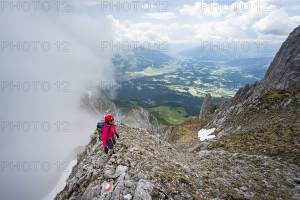 Mountaineer on the rocky ridge, ascent to the Ackerlspitze, clouds moving around the mountains, Wilder Kaiser, Kaiser Mountains, Tyrol, Austria, Europe