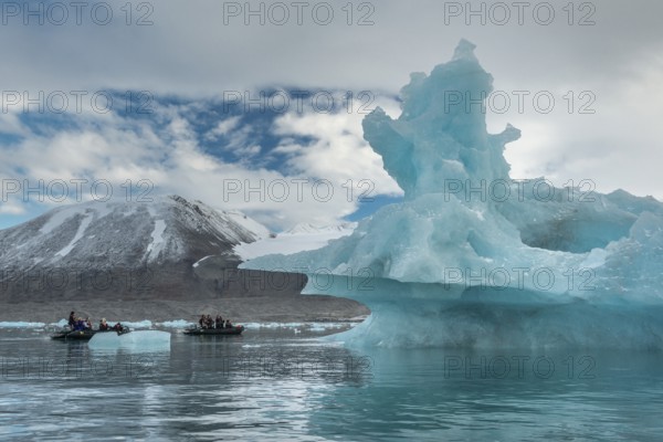 Dinghy with tourists, iceberg, near glacier edge of Monacobreen, Liefdefjord, Woodfjord area, Spitsbergen Island, Svalbard and Jan Mayen archipelago, Norway, Europe