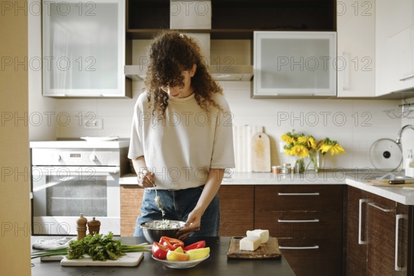 Woman makes stuffing for bell peppers in a bowl in the kitchen