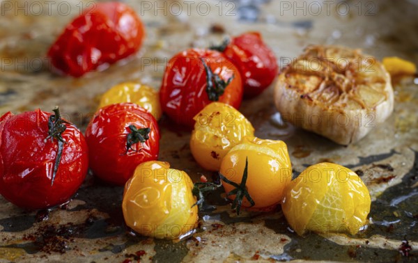Baked cherry tomatoes, in the oven, on a baking sheet, with olive oil and spices, close-up, selective focus, homemade, no people
