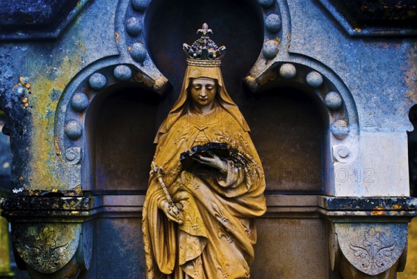 Sculpture of the Virgin Mary reading a book, tombstone in a cemetery, France, color manipulation, Europe