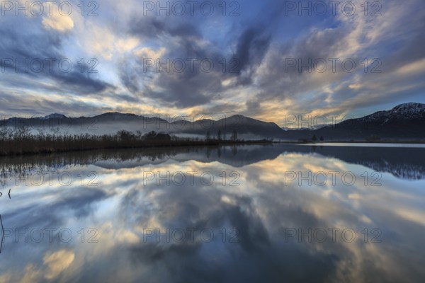 Mountains reflected in a lake at sunrise, cloudy mood, winter, Loisach-Lake Kochel moor, Alpine foothills, Bavaria, Germany, Europe
