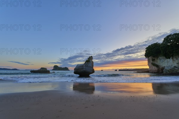 Ocean view with large rocks in the water under a dramatic sunrise sky, Cathedral Cove, Coromandel, Canterbury, North Island, New Zealand, Oceania