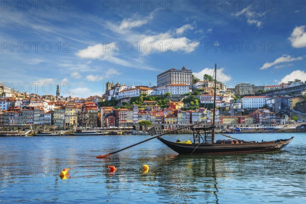 View of Porto city and Douro river with traditional boats with port wine barrels ship from famous tourist viewpoint Marginal de Gaia riverfront. Porto, Vila Nova de Gaia, Portugal, Europe