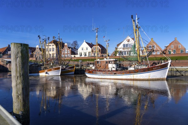 The fishing village of Greetsiel, historic fishing harbour, with the largest shrimp cutter fleet in East Frisia, historic houses, winter, partly frozen, in Lower Saxony, Germany, Europe