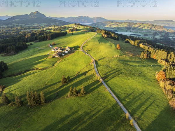 Mountain range near village Wertach, view to mt. Gruenten, sunrise, fog in valley, traditional farm, aerial view, Allgaeu, Bavaria, Germany, Europe