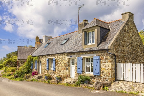 Idyllic old stone cottage by a road in the French countryside with flower pots by the wall on a sunny summer day, Crozon peninsula, Bretagne, France, Europe