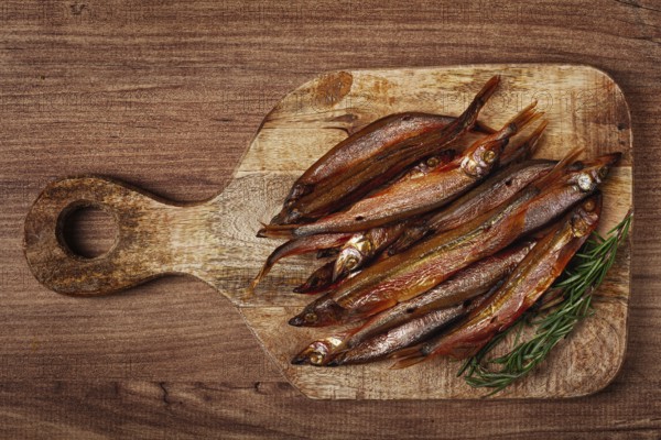 Cold smoked capelin, on a wooden chopping board, no people