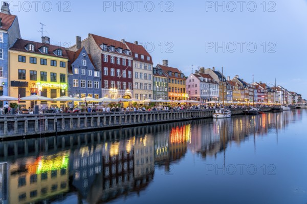 Colourful houses, restaurants and historic ships on the Nyhavn canal and harbour at dusk, Copenhagen, Denmark, Europe