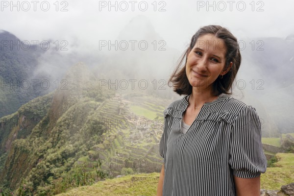 Young woman posing in front of Machu Picchu, Machu Picchu, Cusco Region, Peru, South America